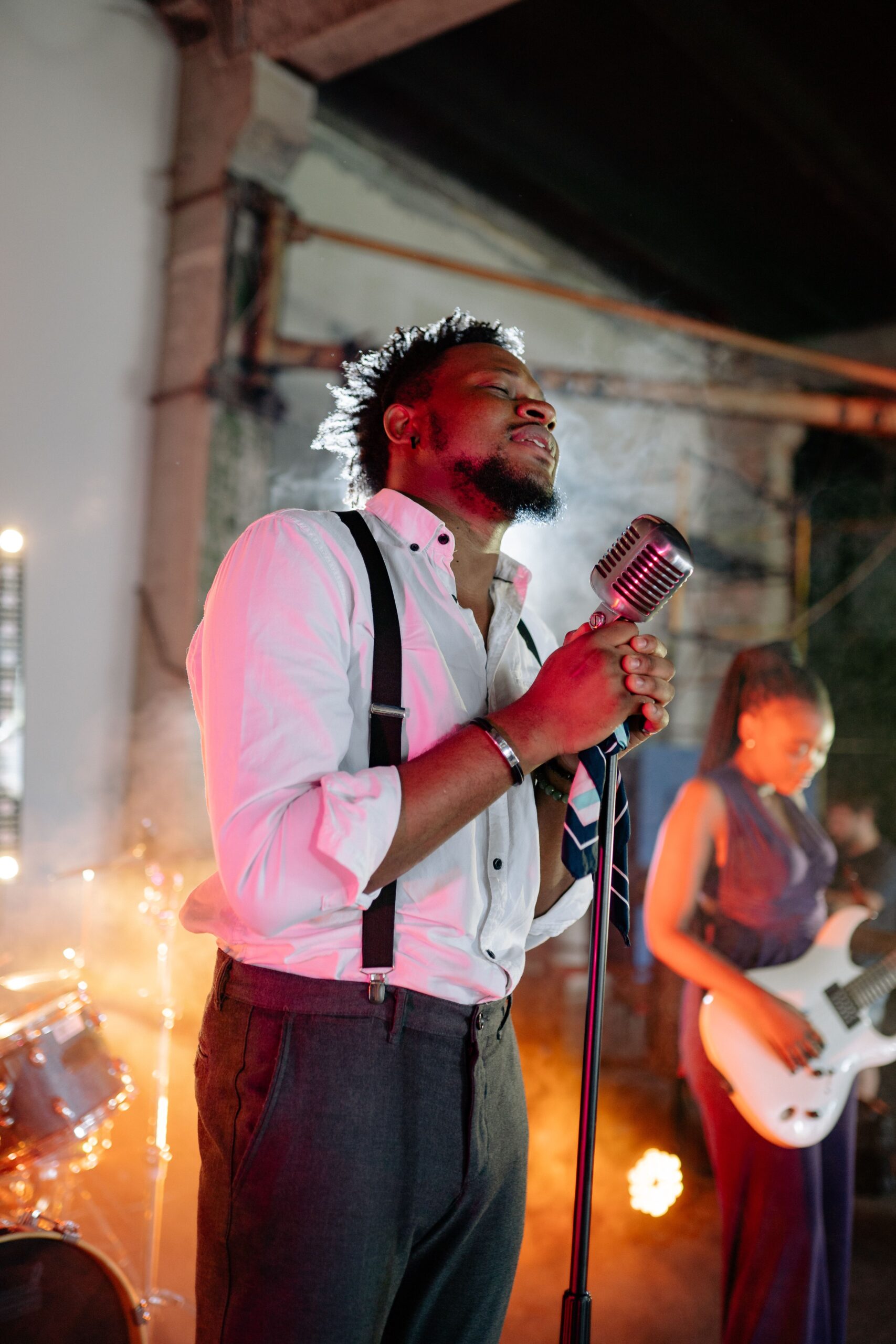 Vibrant live performance showcasing a male vocalist passionately singing with a band.
